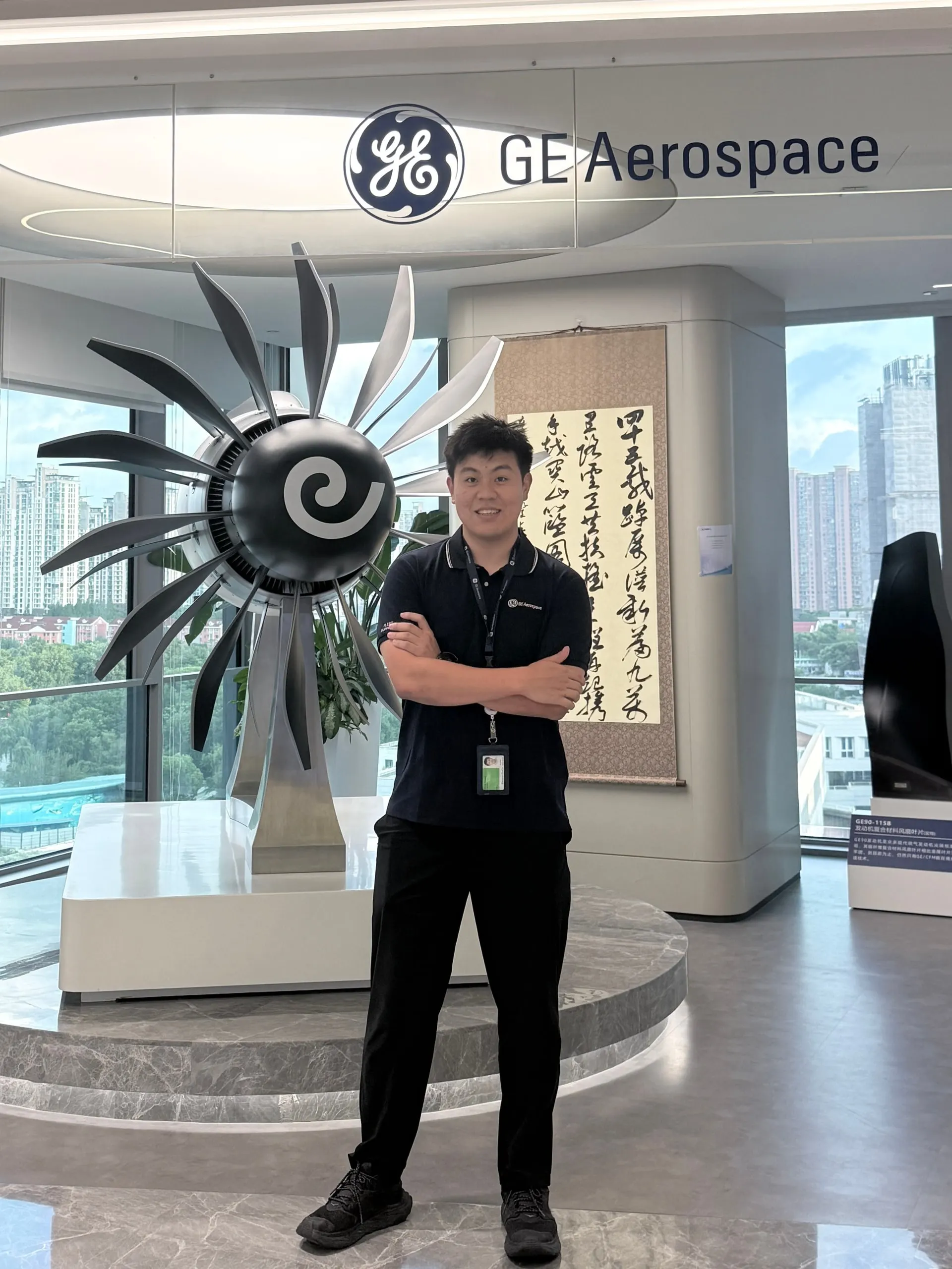 黄泽戎站在 GE 航空航天办公室的发动机风扇展品前